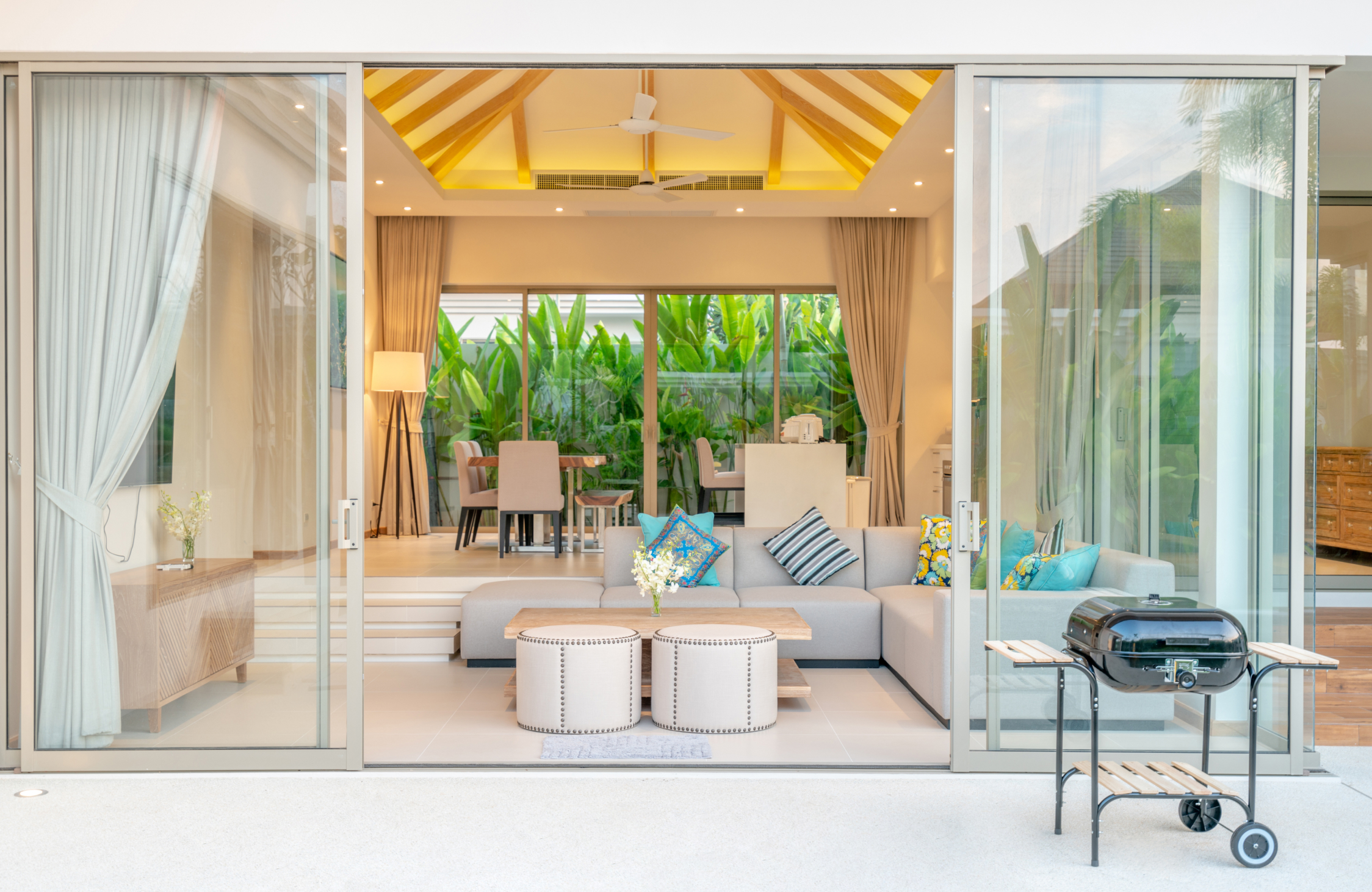 Modern weekend home office with a bright interior, large windows, functional furniture, and views of greenery.