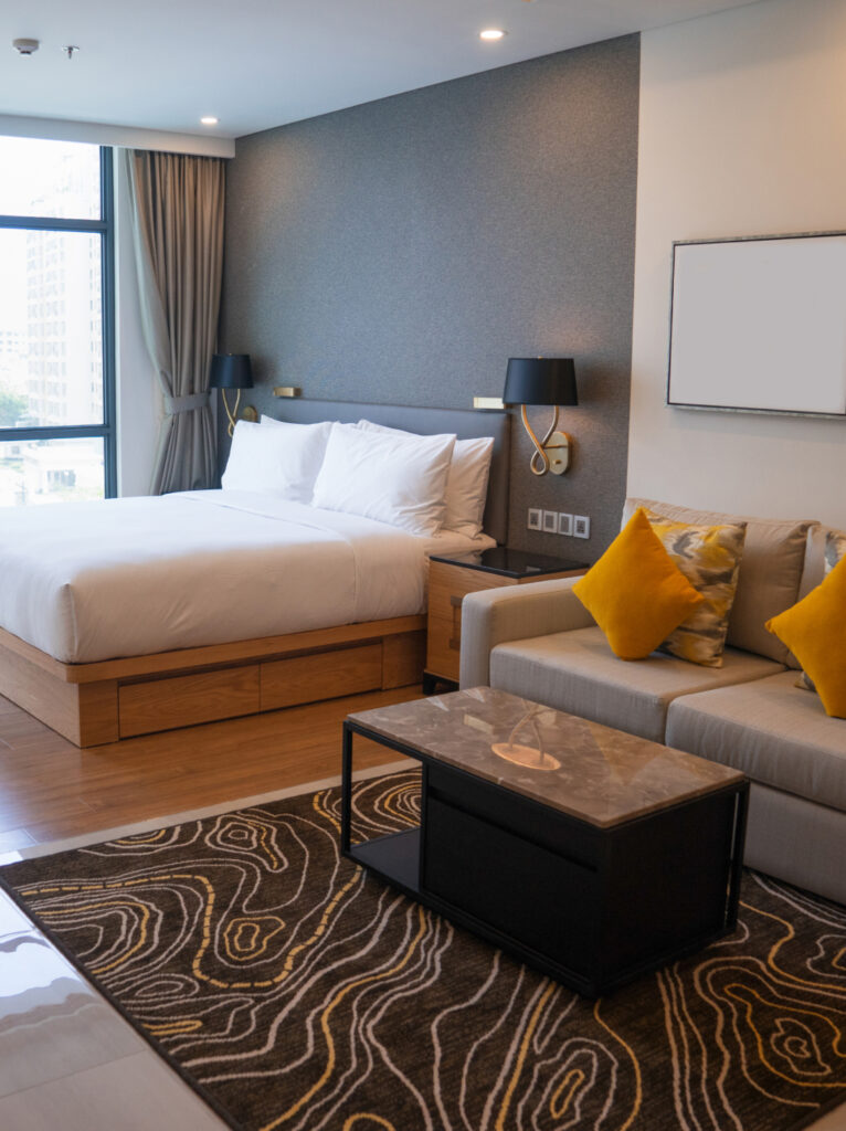 Stylish studio apartment sleeping area with a comfortable bed, warm lighting, and sophisticated interior detailing.