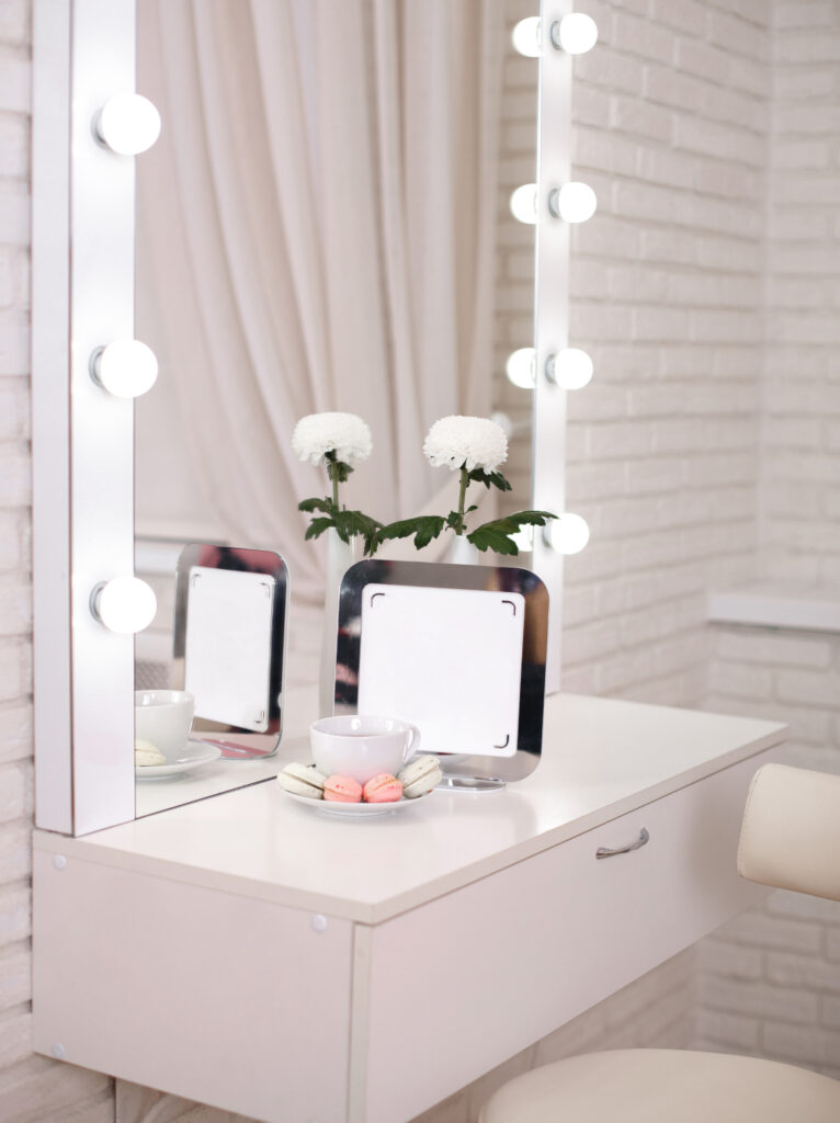 Beauty salon makeup and styling area with illuminated mirrors, organised work counters, and professional equipment.