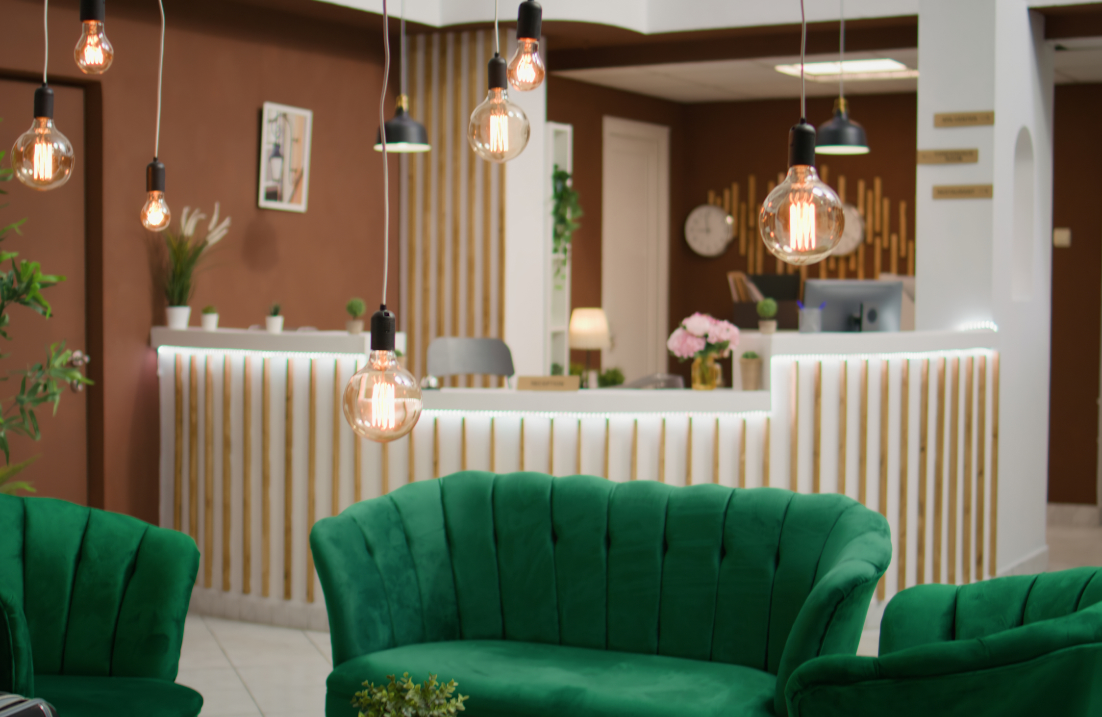 Luxury beauty salon reception desk with vertical detailing, decorative lighting, premium finishes, and comfortable lounge seating.