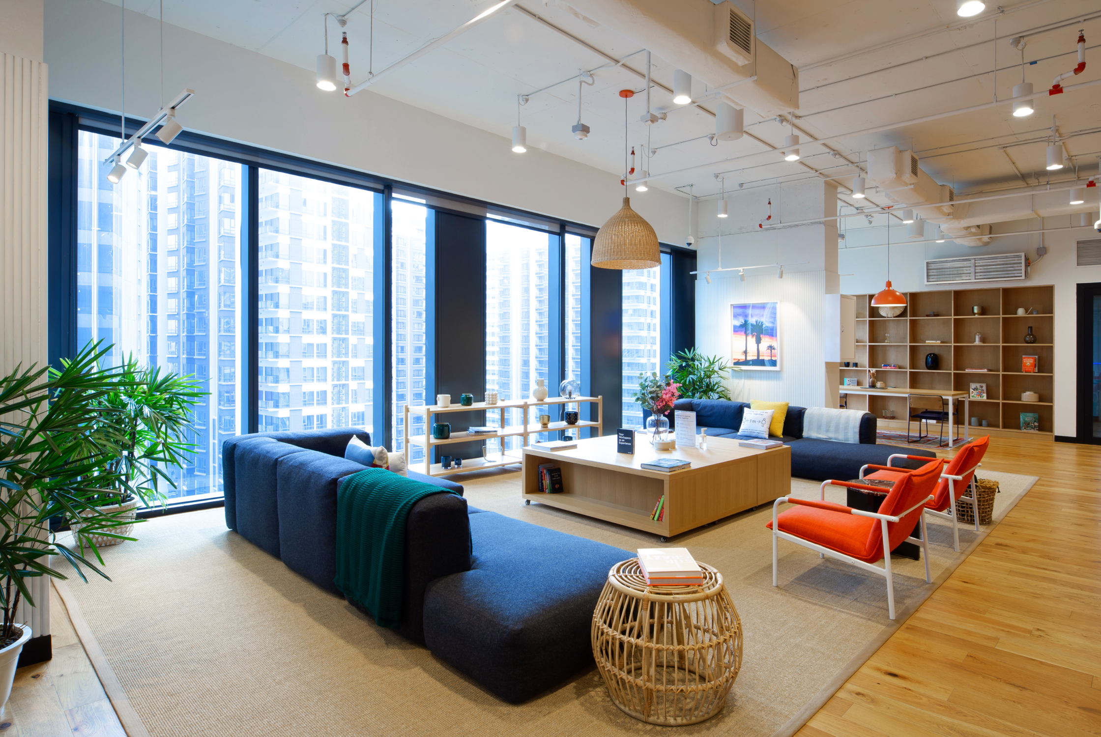 Luxury real estate office lounge with comfortable seating, natural light, contemporary furniture, and a professional atmosphere.